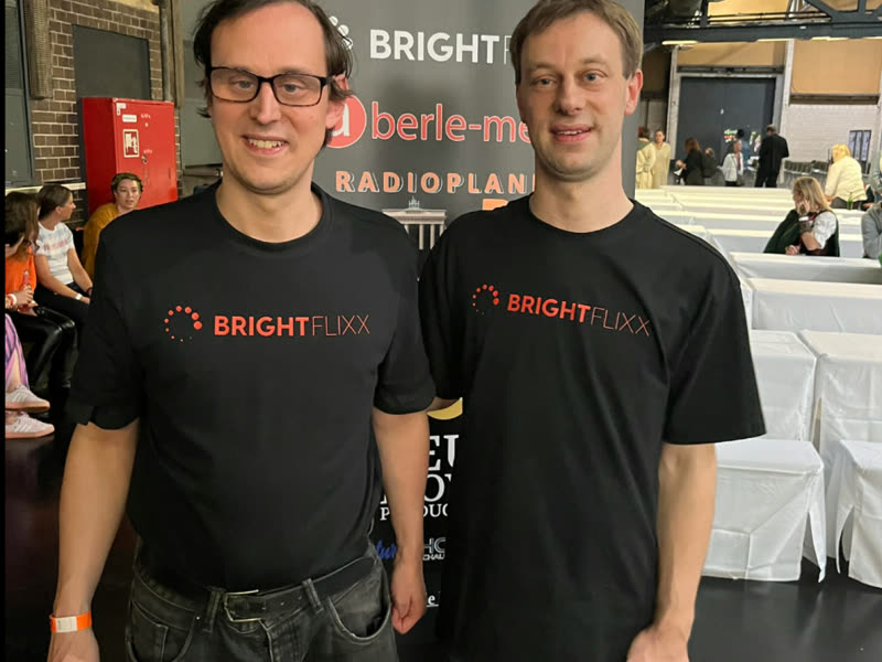 Das BrightFlixx-Team in Marken-T-Shirts am Messestand auf der Buchmesse
